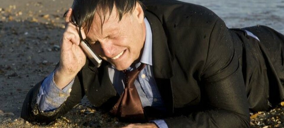 crying business man washed up on beach talks into phone
